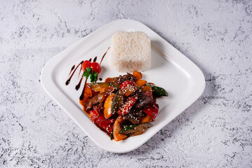 meat with vegetables and boiled rice. on a light concrete background