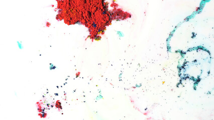 Colorful dry ink moving on white milk background, top view. Close up for powder paint floating on the surface of white liquid, art concept.