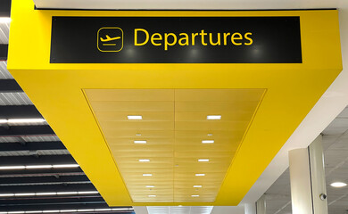 Sign for the departures area in an airport terminal. No people.