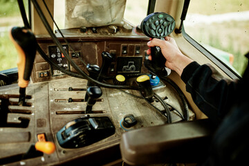 a man driving john deere tracktor with tractor joystick and devices dashboard agriculture farming tractor  © Joel