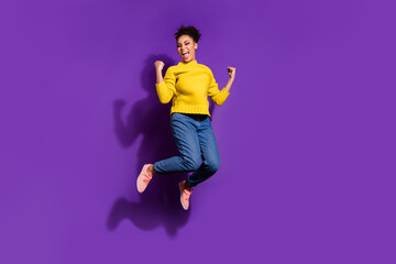 Fototapeta na wymiar Full size photo of delighted nice person raise fists celebrate success jump isolated on violet color background