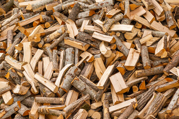 A pile of stacked firewood, prepared for heating the house. Firewood for ready heating in winter.Chopped firewood.environment background.