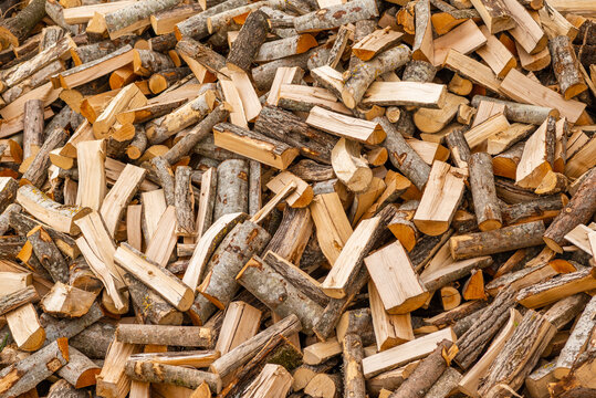 A pile of stacked firewood, prepared for heating the house. Firewood for ready heating in winter.Chopped firewood.environment background.
