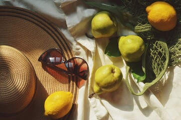 Flat lay summer lifestyle photography. Straw hat, trendy sunglasses, pears and lemons in the evening sunlight. Vacation, travel concept