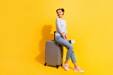 Photo of positive lady looking copyspace sit baggage with visa wait for verification isolated shine color background