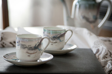 Breakfast or coffee break  in a rustic, intimate and cozy atmosphere. Cups of coffee or tea crafted on an ornate table.