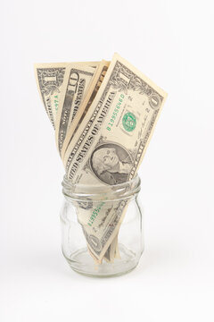 Dollar bills in a glass jar on  white background. Money saving concept.