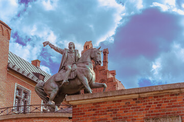 Fototapeta premium Close-up of an equestrian statue with a rider against a blue sky on a sunny day at the western entrance to the Wawel Royal Castle in Krakow, a gift to Poland on behalf of the people of Dresden