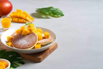 Delicious Japanese souffle pancake with dice mango and jam on white table background.