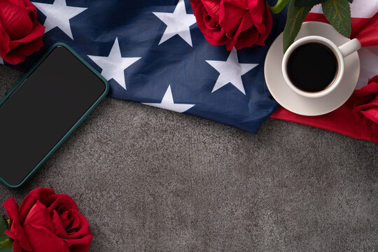 Concept of Independence day or Memorial day with smart phone and coffee. Flag over dark gray table background.