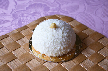 A small no-bake coconut dessert with an almond on top