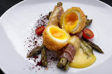 Poached egg, with asparagus, on a dark background