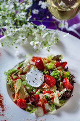 Salad with cheese, strawberries, lettuce, arugula and sauce