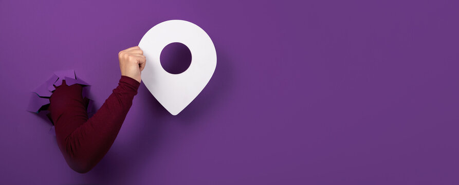 hand holding pin over purple background, panoramic layout