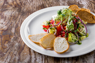 Salad with onions, tomatoes, cheese, lettuce, pesto, mung bean salad, young shoots and bread