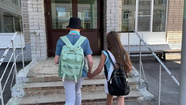 back to school. children return to school after holidays, study at school, boy and girl hold hands and go to school