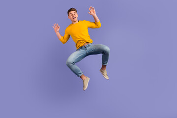 Fototapeta na wymiar Full length photo of young guy have fun jump up wear casual clothes isolated over violet color background