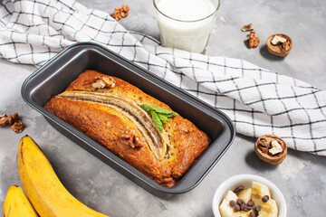 Banana bread or cake in metal baking form on concrete table. Delicious homemade dessert or morning breakfast