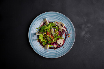 Salad with cheese, pepper, lettuce, endive, sauce and chopped nuts