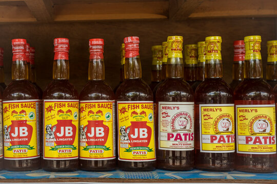 Lingayen, Pangasinan, Philippines - June 2022: Bottles of locally made Patis or fish sauce for sale at a sidewalk stall.
