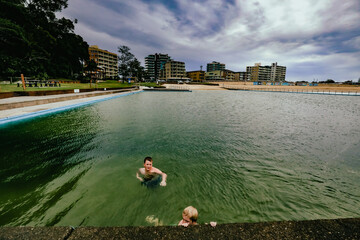 Kids swimming in the Ocean Baths swimming pool at Forster, NSW Australia