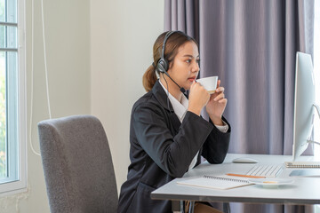 Asian businesswomen with headphone working on computer