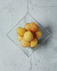 Appetizer of potatoes. French fries in a plastic cup. A small children's portion of a snack of French fries on a gray background