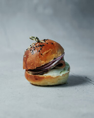 Delicious hot burger on a gray background. Isolate on a gray background. Delicious lunch, snack, food for young people