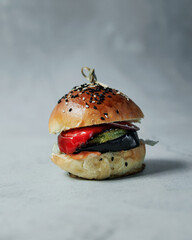 Delicious hot burger on a gray background. Isolate on a gray background. Delicious lunch, snack, food for young people