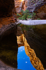 Banded beehive shaped sandstone formations reflecting in water pool in the Cathedral Gorge in the Bungle Bungle National Park, Purnululu, in the Kimberley Region of Western Australia
