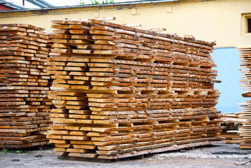 Lumber storage. Wood boards piles stored outdoor. Stacked wooden boards at lumberyard. Stack of lumber at outdoor warehouse. Stockpiled boards