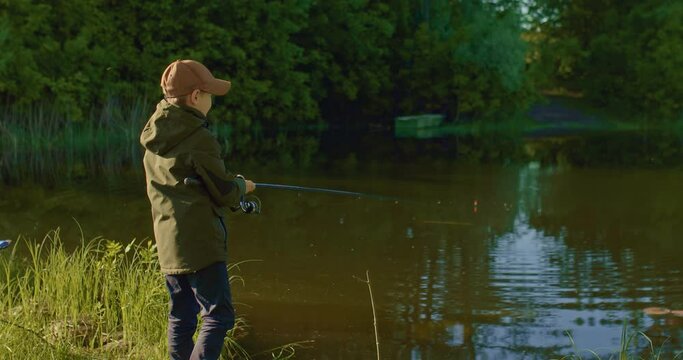 happy little fisher is pulling fish from lake in summer morning, hooking and rejoicing, 4K, Prores