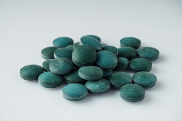 green spirulina dried seaweed on a white acrylic background