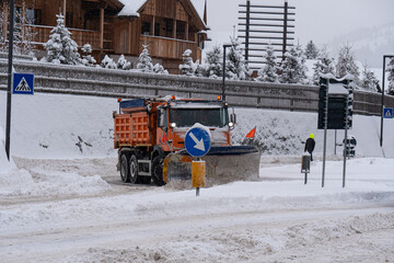 Road Vehicle Snowplow in action on Whitewashed Roads During a Snowy Day