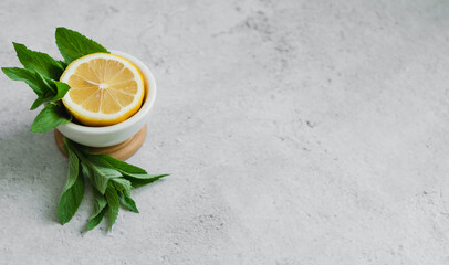 lemon and mint on gray background. copy space for text. ingredients for summer drinks
