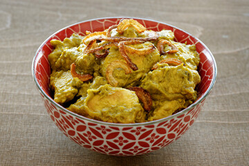 Turkey meat in coriander chutney with fried onion. Indian cuisine dish.