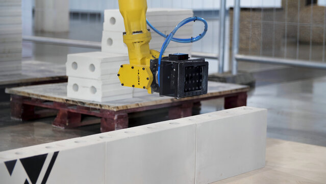Industrial robot exhibit at work. Media. Bricklayer robot for automated building construction, concept of robotic technologies in construction industry.