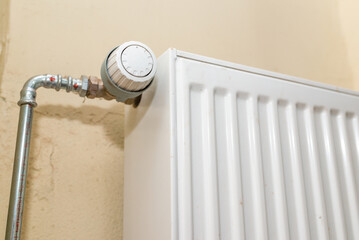 Old white radiator thermostat with copy space,closeup,selective focus,yellow background.