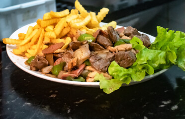 Mixed pork, chicken, calabrian and french fries with salad served in Brazilian pub