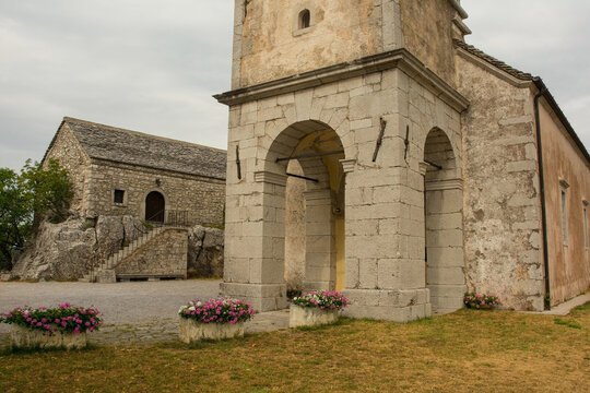 The Sanctuary of Monrupino church, also called Santuario di Santa Maria Assunta, in Rocca di Monrupino near Trieste in Friuli-Venezia Giulia, north east Italy. Casa della Comunanza in the background