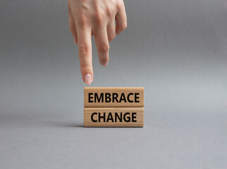 Embrace change symbol. Concept word Embrace change on wooden blocks. Beautiful greybackground. Businessman hand. Business and Embrace change concept. Copy space