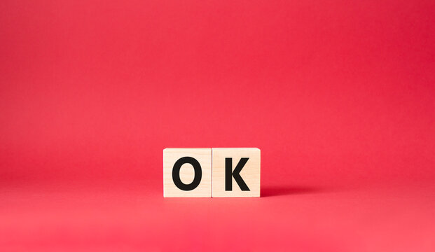 Ok symbol. Concept word Ok on wooden cubes. Beautiful red background. Business and Ok concept. Copy space.