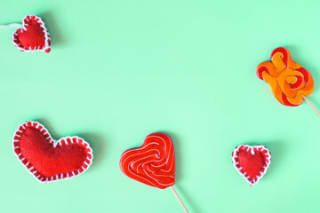 Abstract background of sweet lollipops and red hearts on a light background top view.