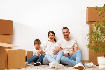 Young parents and son having fun during moving day to new house