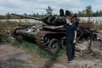 Man stands near destroyed and burned by the Ukrainian army russian tank near Kyiv.