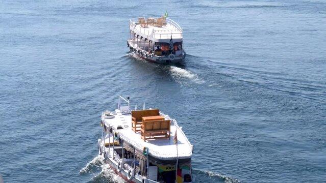 Two traditional boats crusing on the Nile river with a view Aswan, Egypt.
