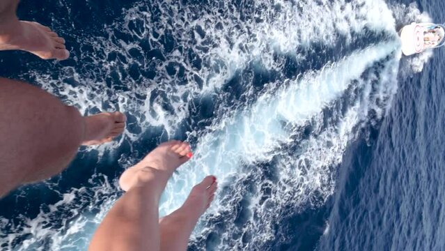 POV view of parasailing caucasian man and woman legs over the sea.