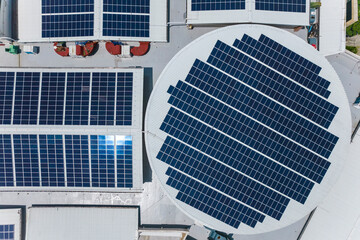 Top view of an array of polycrystalline solar panels installed on the roof of a shopping mall.