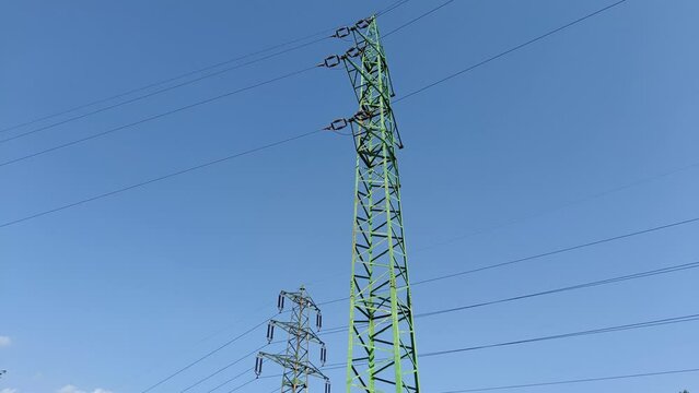 Electric lines on two high pylons transferring electricity