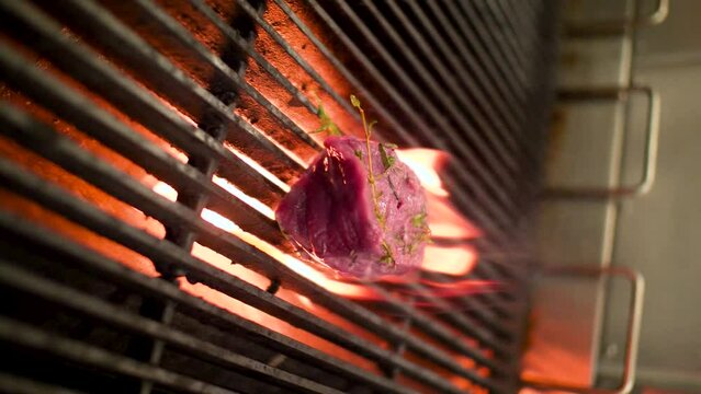 Steak with seasion cooking on a fire grill indoors.